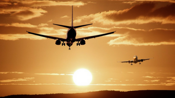 Two airplanes in the sky: One flying away from the camera and one flying towards