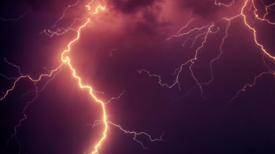 Warm flashes on lightning set against a darkish purple sky