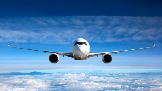 airplane flying through a blue sky over the clouds