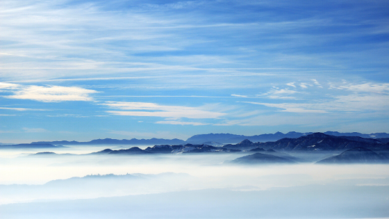Fog covering the ground with mountains is the background