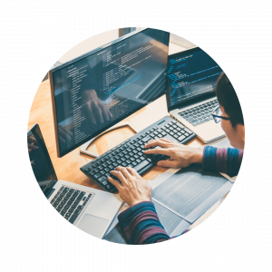 A student coding on three different computers
