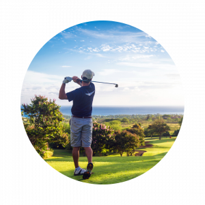 A male golfer finishing his swing at a well maintained golf course