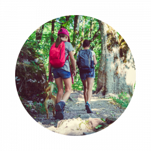 Two young girls walking on a wooded path