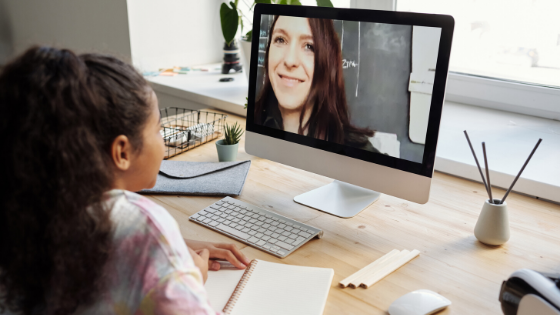 a student learning via remote instruction from a teacher on a computer screen