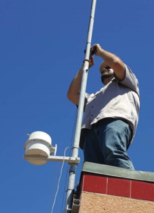 An Earth Networks field technician installing an Earth Networks weather station